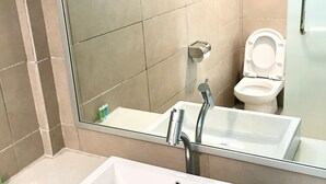 A bathroom with a white sink, a mirror, and a toilet.