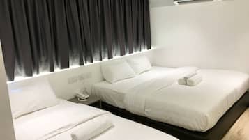 Habitación de hotel con dos camas, una mesita de noche con teléfono y un equipo de aire acondicionado en la pared.