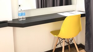 Una habitación con escritorio, silla, aire acondicionado y espejo.