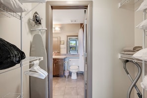 A narrow hallway leading to a bathroom with a toilet, sink, and shower. - Playa Del Sol Retreat 550 | Pool + Hot Tub | Sleeps 6 (Kelowna)