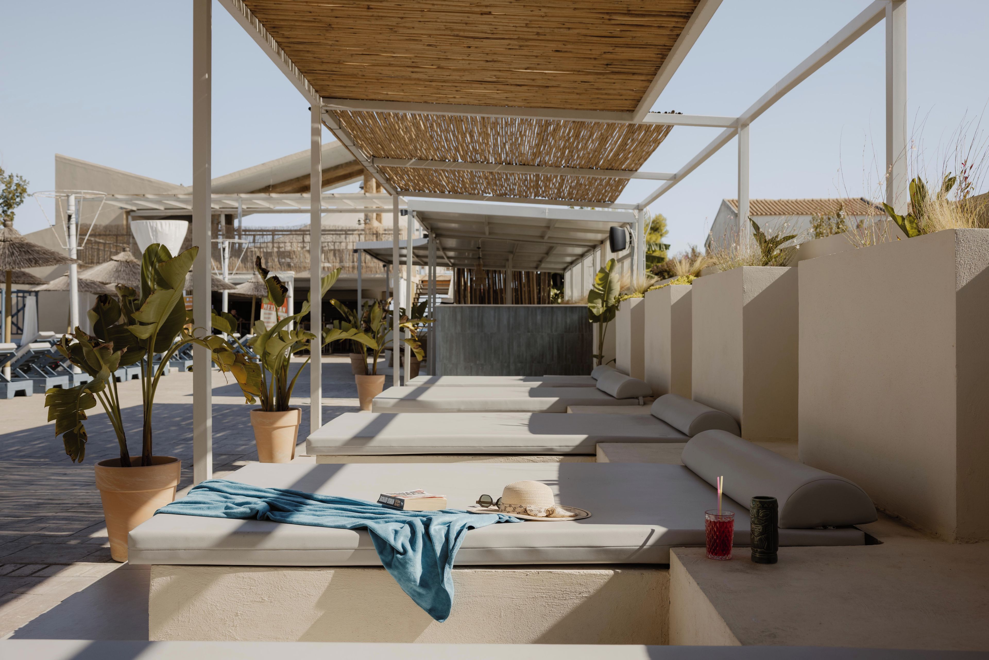 A modern outdoor seating area with planters and a covered section.