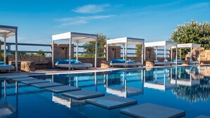 A pool area with white canopies and blue cushions. - Paralia Studios (Corfu)