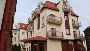 A hotel with a classic European architectural style, featuring balconies, a red-tiled roof, and a sign indicating it is a hotel. - Hotel Rydzewski (Elk)