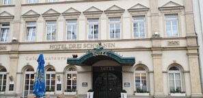 Das Hotel Drei Schwannen mit Café und Restaurant, einem markanten Eingang und klassischer Architektur.