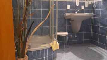 Un baño con bañera, lavabo y cabina de ducha de vidrio.