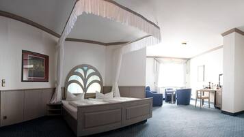 Ein Hotelzimmer mit einem großen Bett, einem Schreibtisch und einem Stuhl.