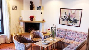 A living room with a sofa, two armchairs, a coffee table, and a fireplace. - Hotel garni  Zur Weserei (Kandern)