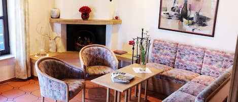 Una sala de estar con un sofá, dos sillones, una mesa de centro y una chimenea.