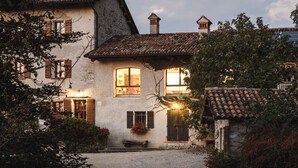 A rustic building with a stone facade, wooden shutters, and a tiled roof. - Telva Alta, country house with tennis in the Dolomites  (Feltre)