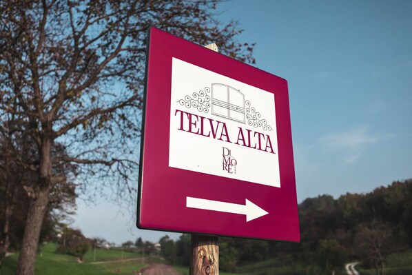 A directional sign with 'TELVA ALTA' and an arrow pointing right.