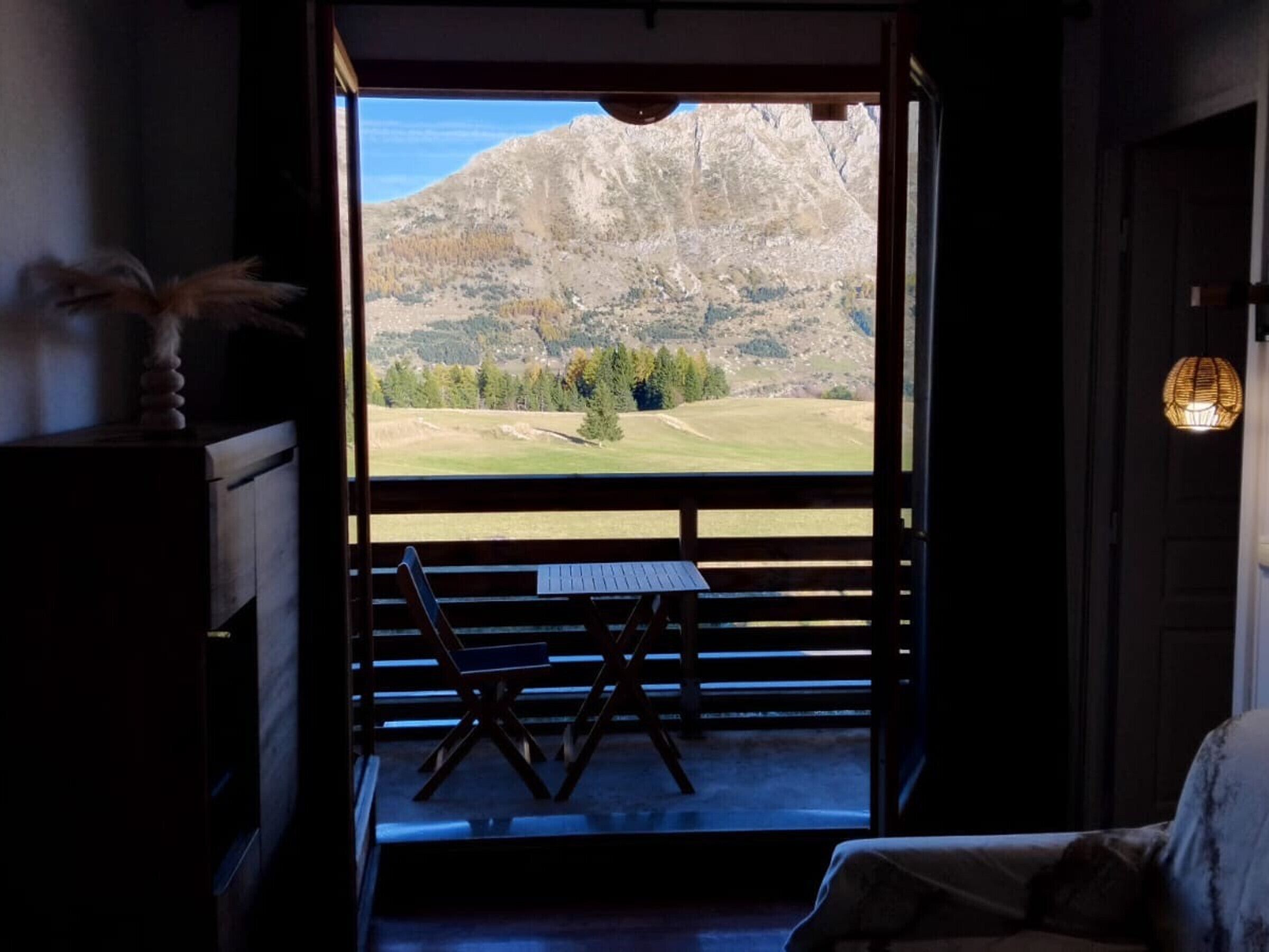Una habitación con vistas a un paisaje montañoso a través de un amplio ventanal.