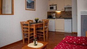A compact living space with a dining area, kitchenette, and a sofa. - Cozy 2-room apartment for 4, mountain view balcony, pets allowed. (Le Dévoluy)
