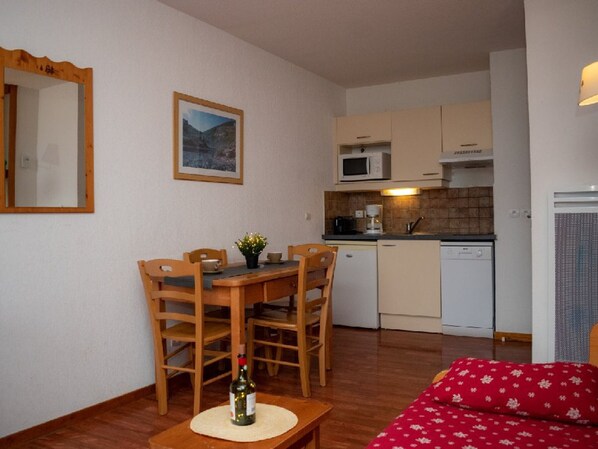 A compact living space with a dining area, kitchenette, and a sofa. - Cozy 2-room apartment for 4, mountain view balcony, pets allowed. (Le Dévoluy)