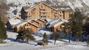 Un grand chalet en bois doté de nombreux balcons et surplombant un paysage montagneux.