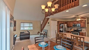 A spacious kitchen with wooden cabinets, a central island, and a dining area with a table set for four. - 6 Mi to Skiing: Family Poconos Home w Decks! (Albrightsville)