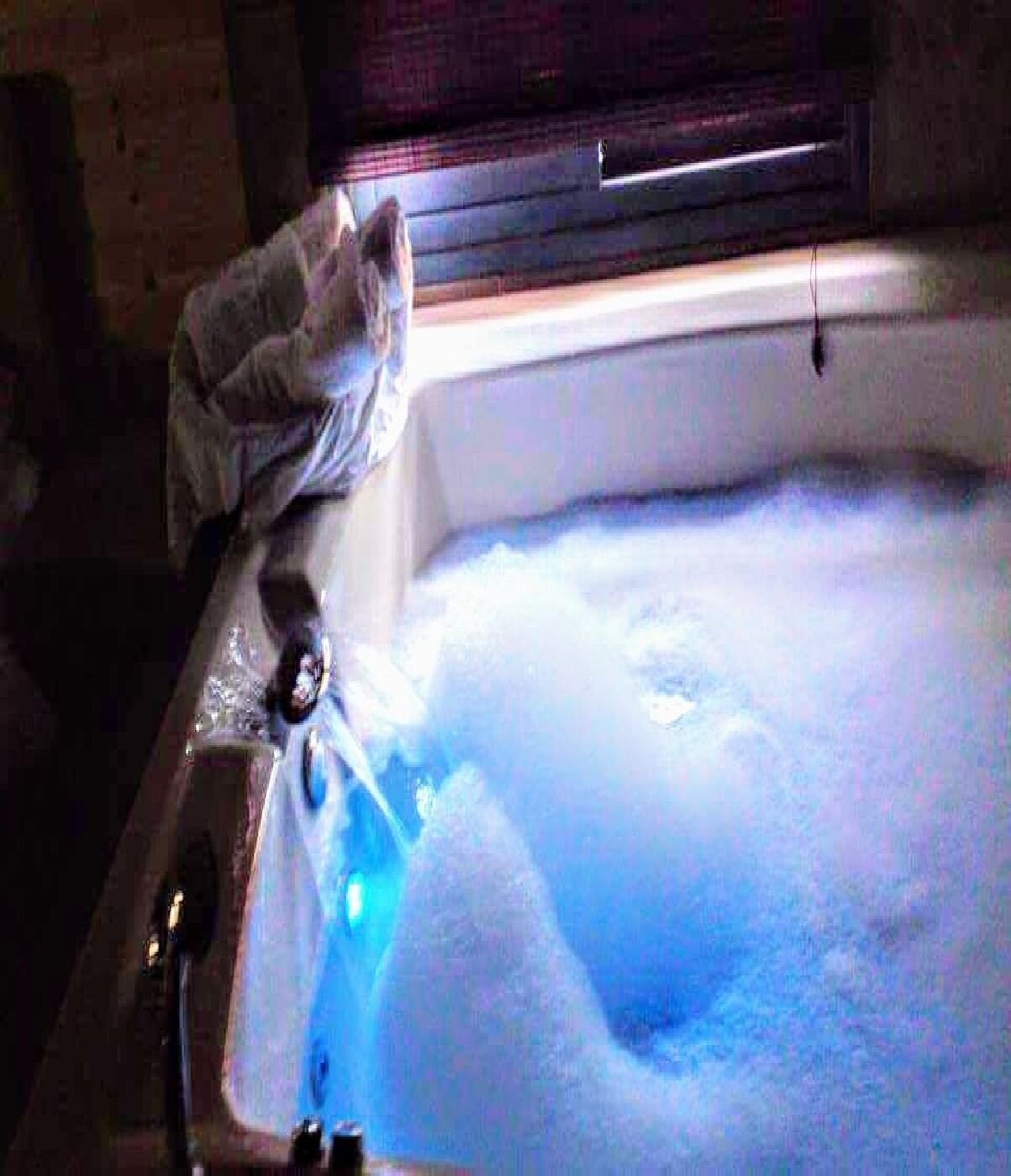 Eine Badewanne mit Schaum, ein Handtuch und eine Flasche.