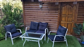 A wooden cabin with a glass table and four chairs with cushions. - Pearl Of The North (Hazor Haglilit)