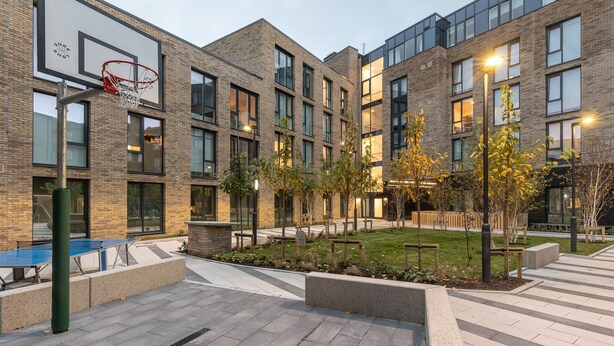 A modern building with a basketball court, outdoor seating, and a well-maintained garden area. - Dominick Place (Dublin)