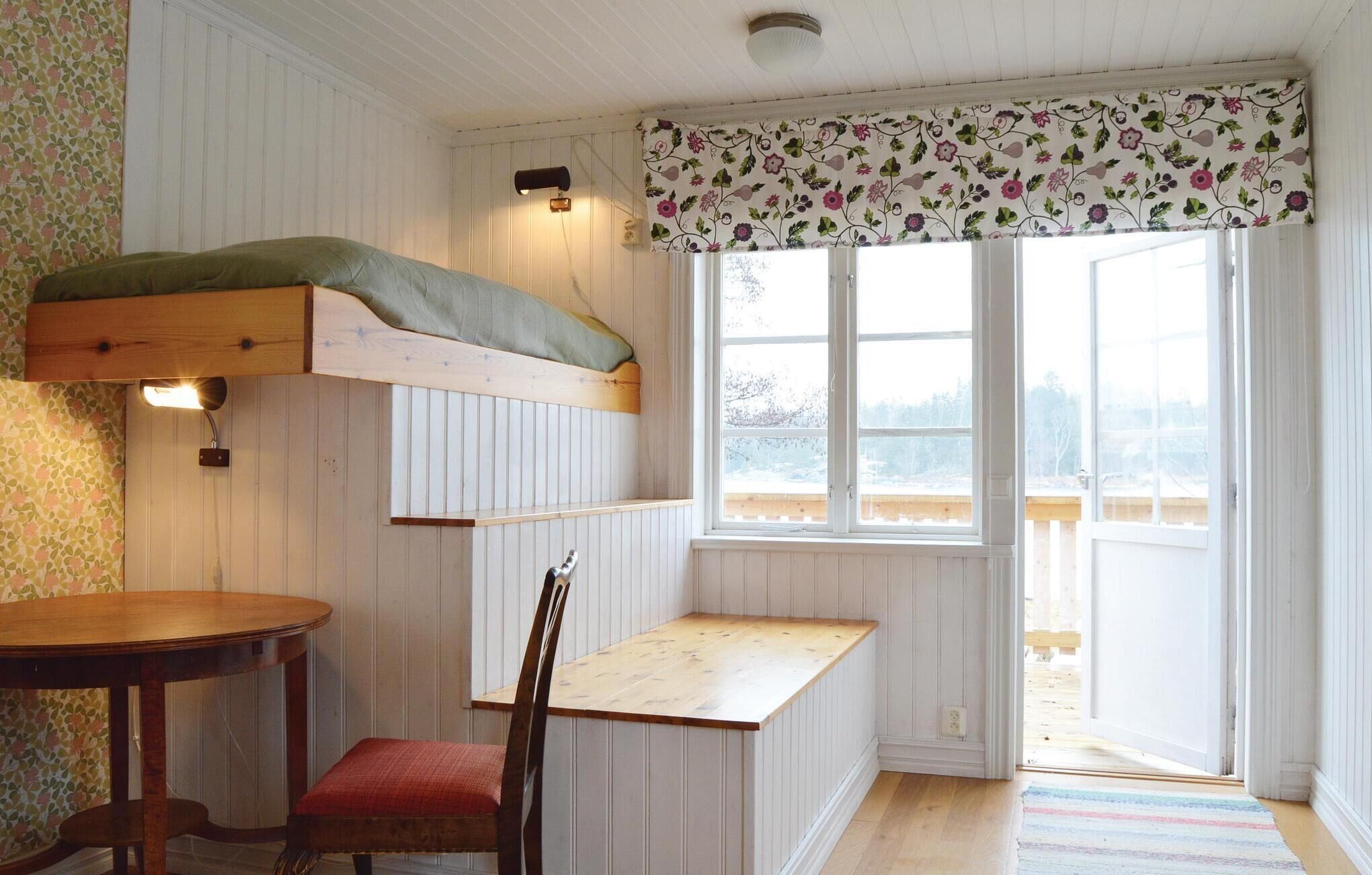 A cozy room with a loft bed, a small dining table, and a bench.