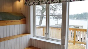 A cabin room with a window overlooking a wooden deck and a lake. - Lovely home in Gräddö with sauna (Gräddö)