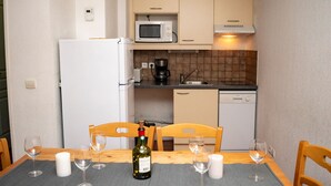 A compact kitchen with a refrigerator, microwave, coffee maker, and dishwasher. - 3-room apartment for 6 people, mountain view, pets allowed (Le Dévoluy)