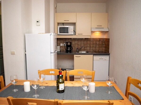 A compact kitchen with a refrigerator, microwave, coffee maker, and dishwasher. - 3-room apartment for 6 people, mountain view, pets allowed (Le Dévoluy)