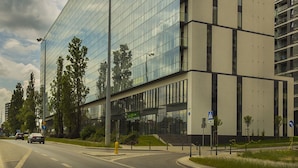 Een modern glazen gebouw met een platte gevel en verschillende balkons.