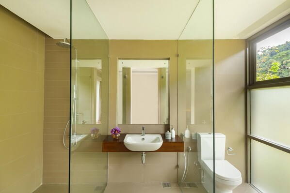 A modern bathroom with a glass shower enclosure, a wooden vanity, and a toilet. - Jetwing Kandy Gallery, A Luxury Reserve (Kandy)
