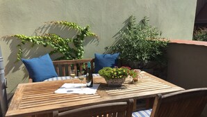 A wooden table with two chairs, a bottle of wine, and a vase with flowers. - Stadthaus Rosengasse (Meissen)