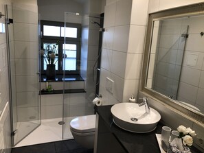 Comfort appartement | Badkamer | Een haardroger, handdoeken, zeep, shampoo