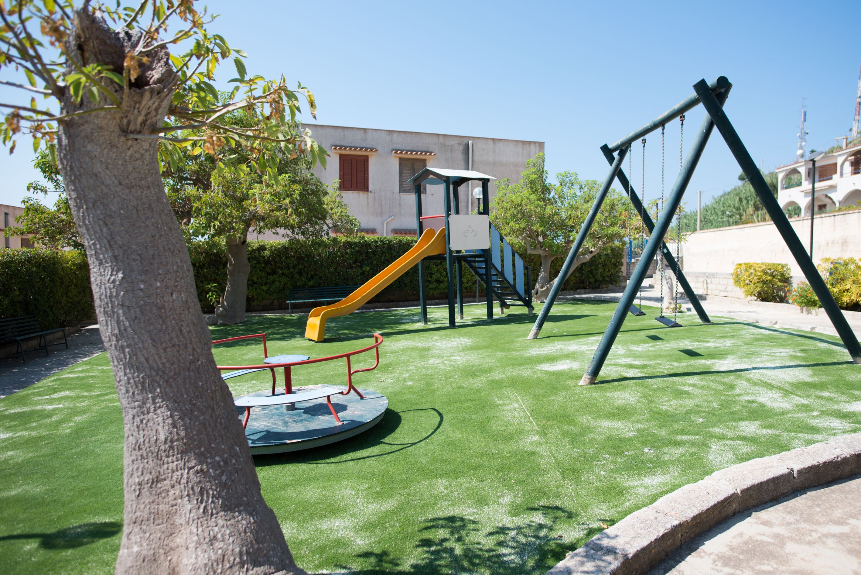 A playground with a slide, swings, and a circular play area.