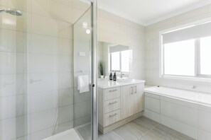 Bathtub, hair dryer, towels, toilet paper
