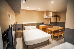 Ein modernes Hotelzimmer mit Bett, Nachttisch, Schreibtisch und Stuhl.