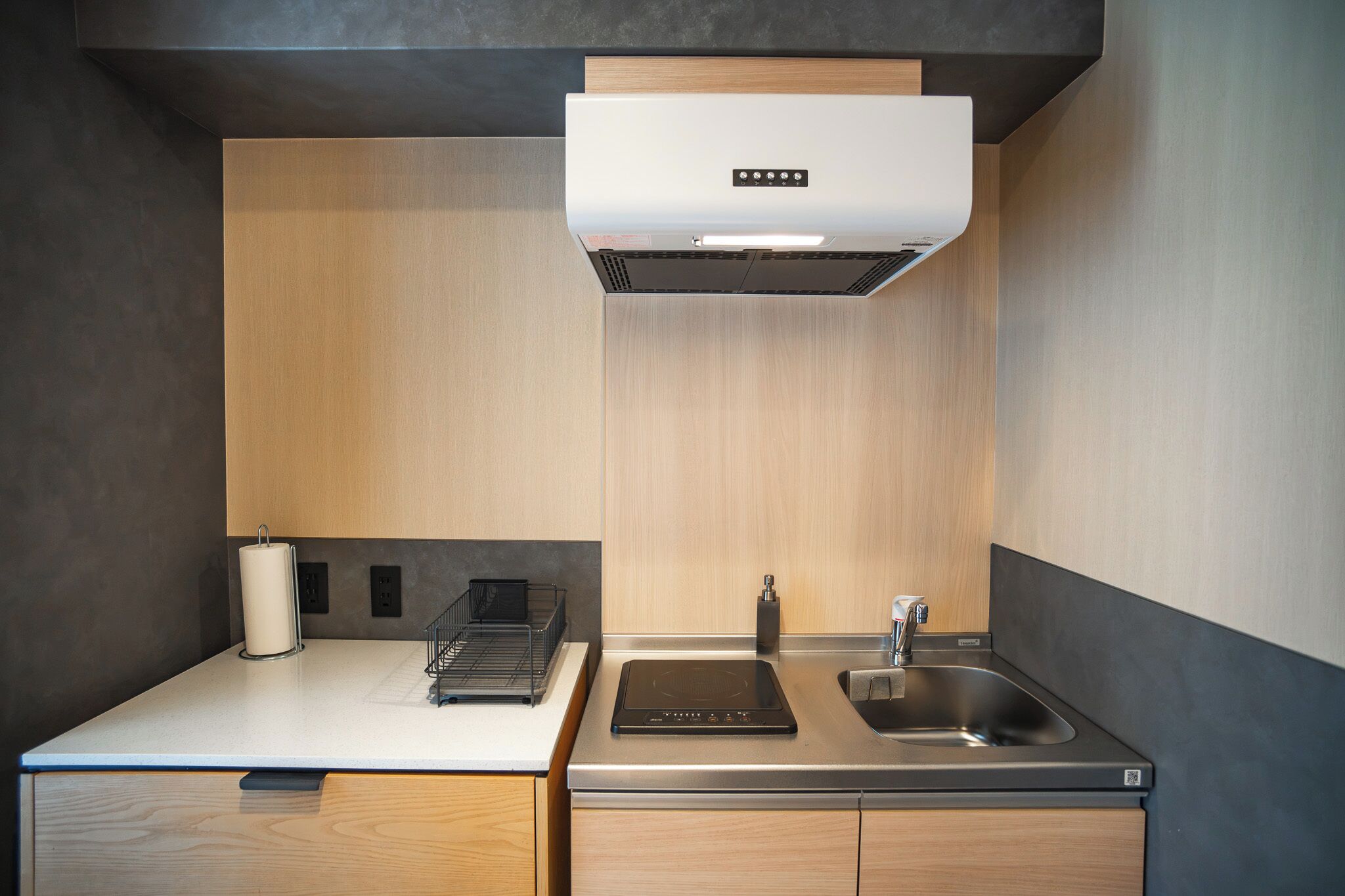 A modern kitchen with a built-in stove, a sink, and a range hood.