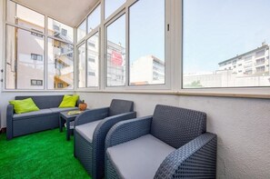 Relax in this stylish room with a city view, featuring a sofa, armchair, and small table.