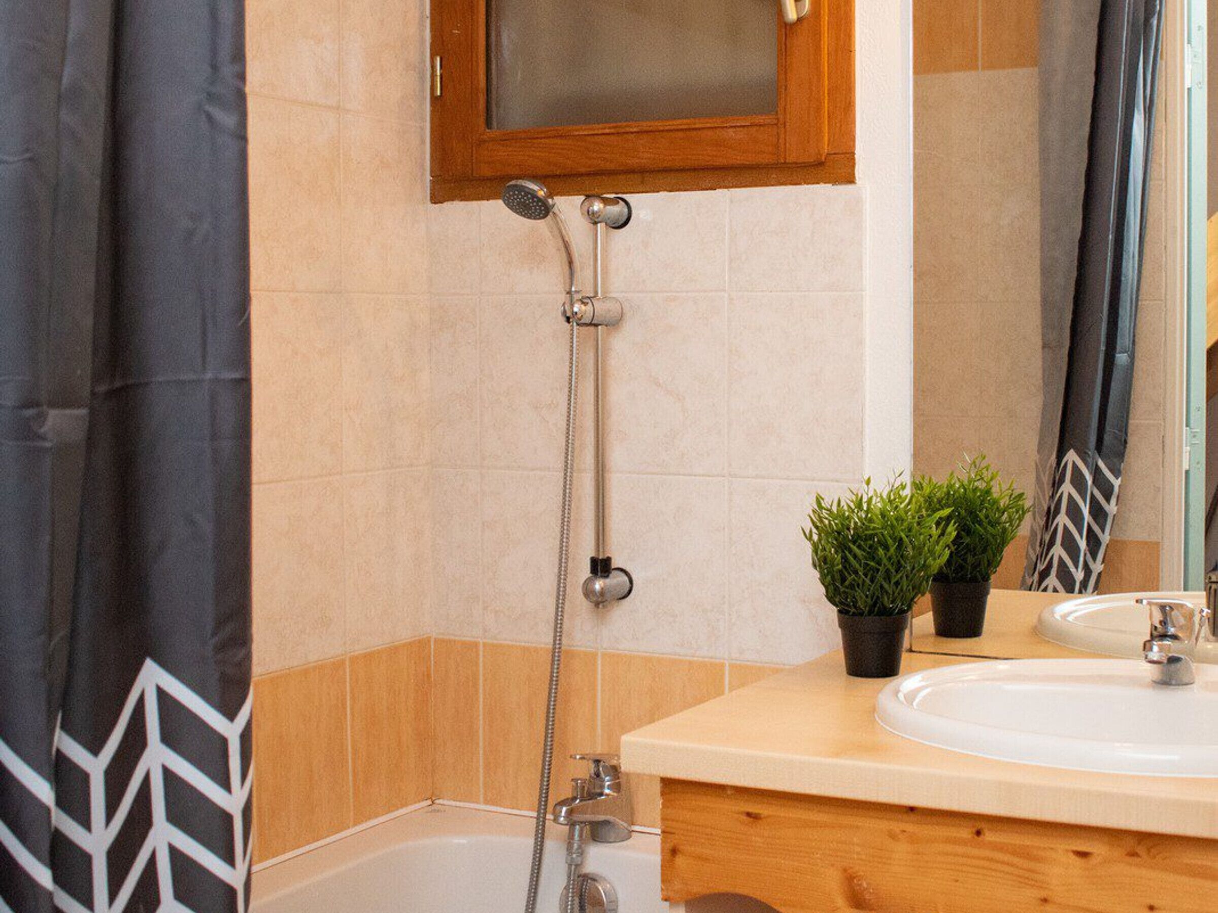 Un baño con ducha, lavabo y espejo.
