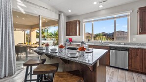 A modern kitchen with a large island, wooden cabinets, and a dishwasher. - Paradise Village 115, Poolside Heaven, has a Private Hot Tub, and View of Lazy River (Santa Clara)