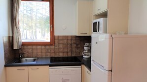 A small kitchenette with a sink, stove, microwave, and refrigerator. - Duplex Chalet 3 Rooms for 6 People in Superdévoluy (Le Dévoluy)