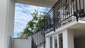 Un escalier avec une rampe noire menant à un balcon.