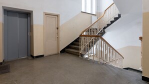 Una escalera con barandilla de metal y piso alfombrado.