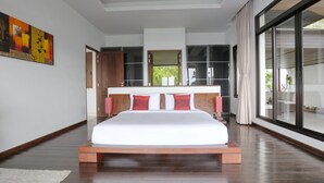 Une chambre moderne avec un grand lit, une tête de lit en bois et une vue dégagée grâce à une porte-fenêtre coulissante.