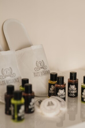 Une trousse de toilette contenant un sac de bain blanc et plusieurs flacons de gel douche et de lotion pour le corps.