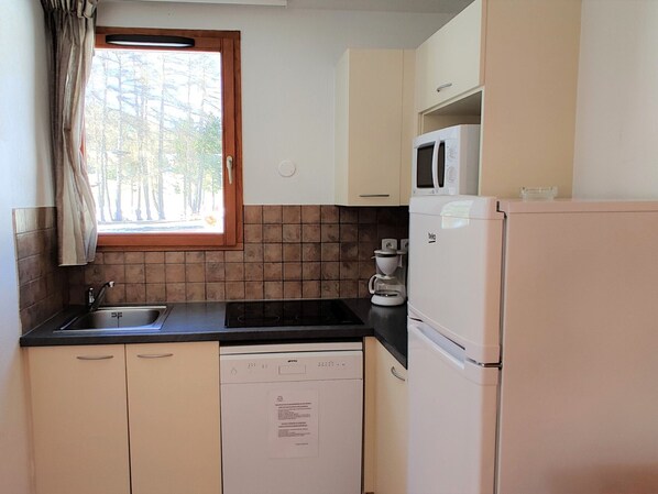 A small kitchenette with a sink, stove, microwave, and refrigerator. - Charming 3-room chalet for 6 guests in Superdevoluy (Le Dévoluy)