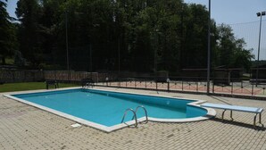 A rectangular swimming pool with a brick deck, metal pool ladder, and a bench. - Bungalow with Garden View (Palestrina)