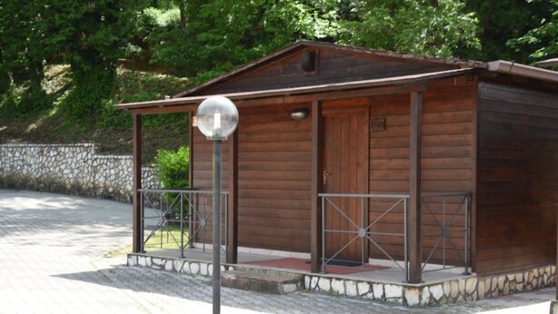 A small wooden cabin with a metal railing and a spherical light fixture. - Bungalow with Garden View (Palestrina)