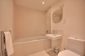 A bathroom with a bathtub, sink, toilet, and a mirror. - Cheapside by Top House (Liverpool)