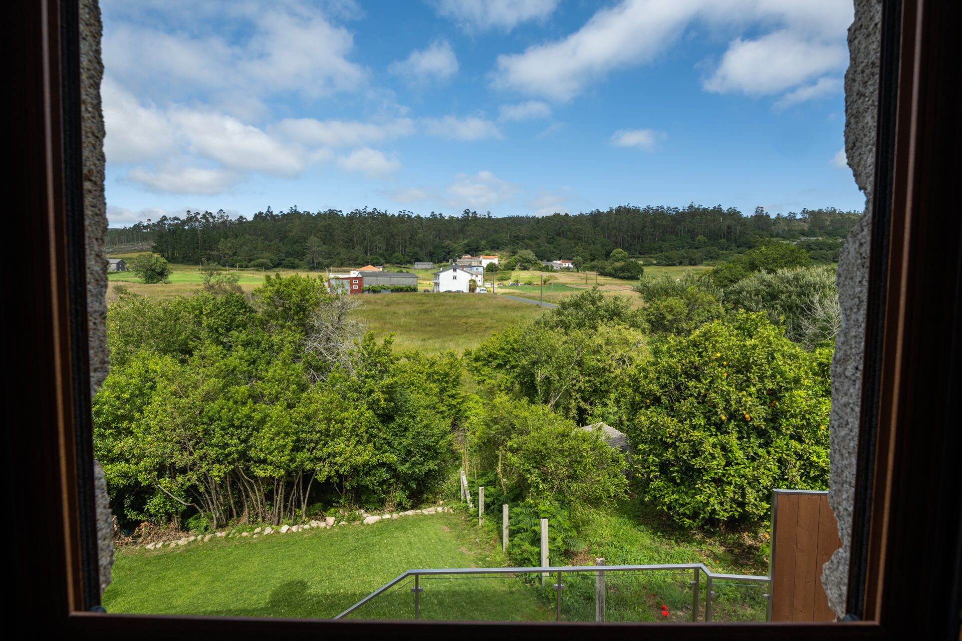 Un paisaje rural con una casa, campos y árboles.