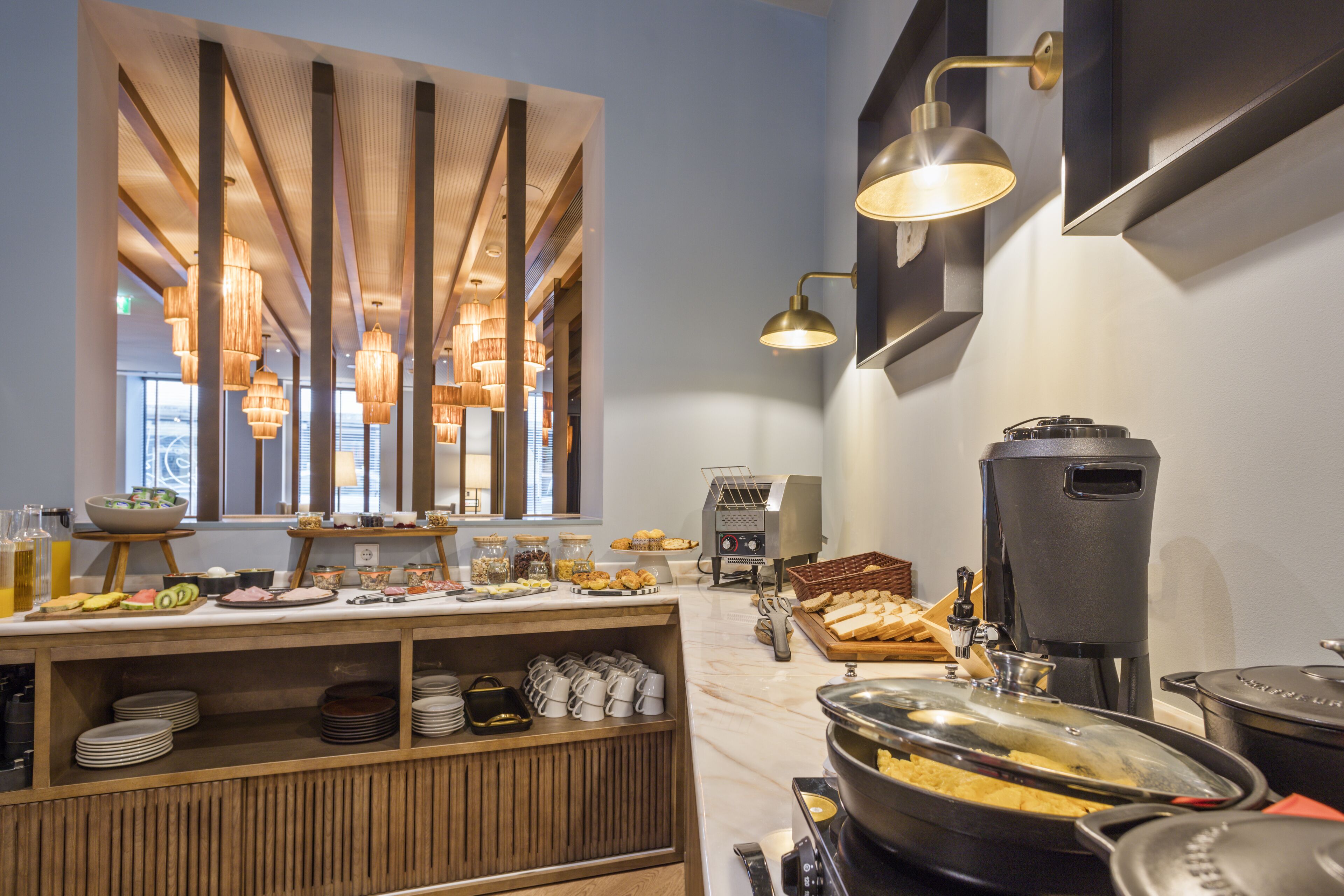A buffet area with a variety of food items, a coffee machine, and a self-service beverage station.