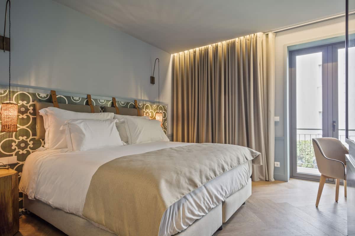 Een moderne hotelkamer met een groot bed, een bureau en uitzicht op de omgeving.