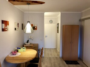 Ein Essbereich mit Holztisch, Stühlen, einer Pendelleuchte und einem Holzschrank.
